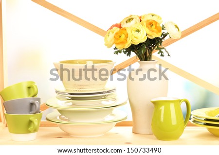 Beautiful dishes on wooden cabinet on bright background