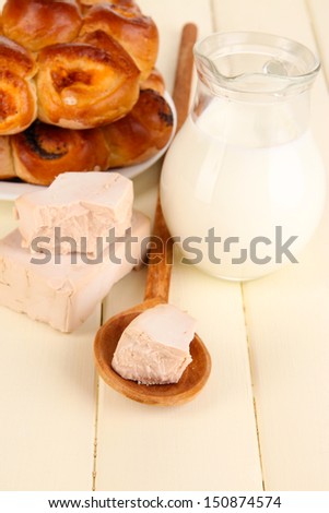 Dry yeast with pastry on wooden table close-up