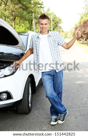 Man on road with car breakdown trying to stop car