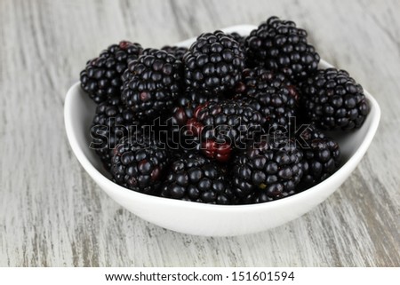 Sweet blackberries in bowl on table close-up