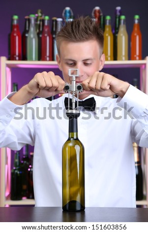 Bartender opens bottle of wine
