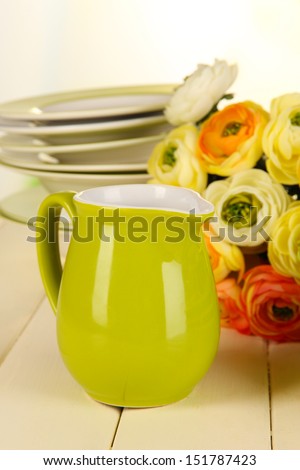Lots beautiful dishes on wooden table on bright background