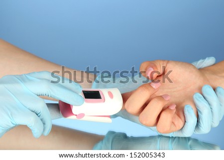 Pulse oximeter used to measure pulse rate and oxygen levels, on color background