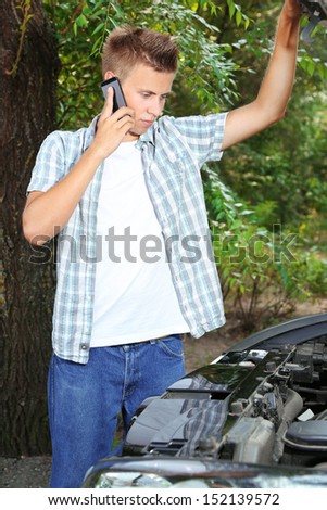 Man calling repair service after car breakdown