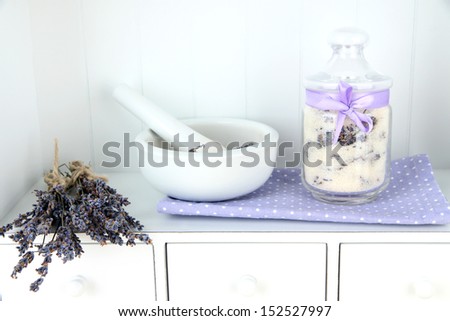 Still life with jar of lavender sugar, mortar and fresh lavender flowers on shelves