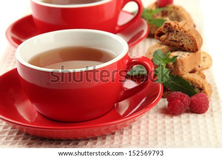 Cup of tea with cookies and raspberries close-up