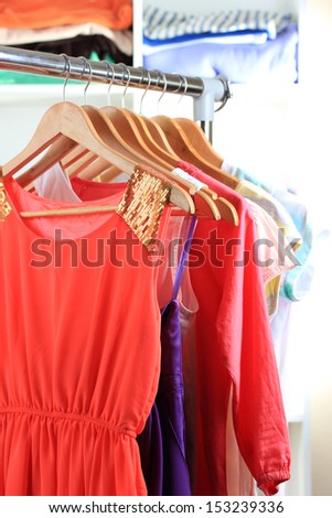 Variety of clothes on wooden hangers on shelves background