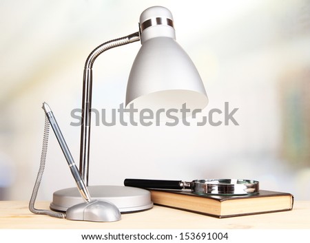 Table lamp and book on desk in room