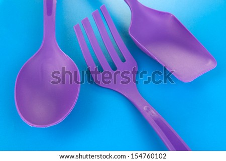 Plastic kitchen utensils on blue background