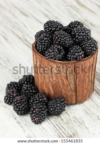 Sweet blackberries in wooden basket on table close-up