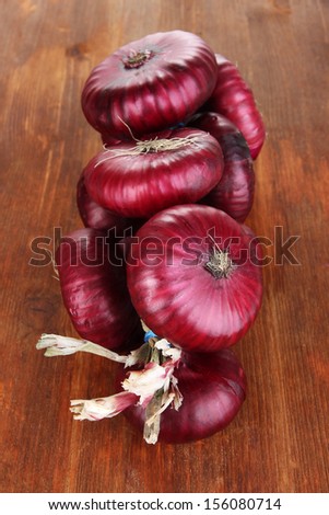 Fresh red onions on wooden background