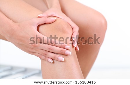 Girl with sore foot on gray background