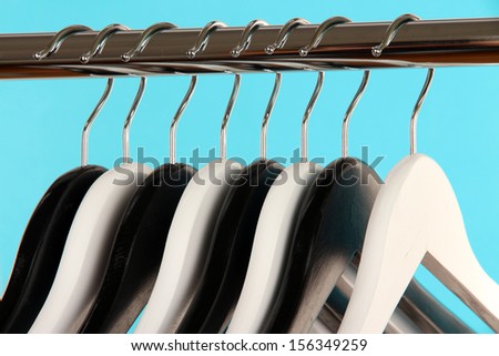 Black and white clothes hangers on color background