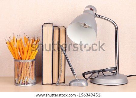 Table lamp with books on desk in room