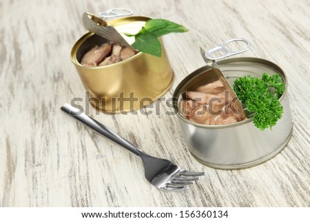 Open tin cans, on wooden background