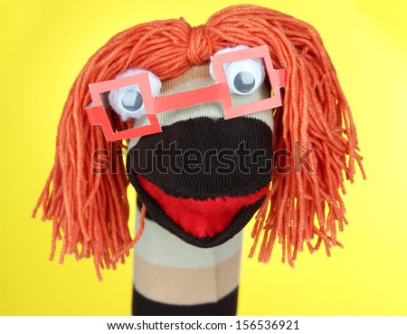 Cute sock puppet on yellow background