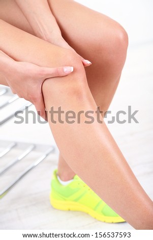 Girl with sore foot on gray background