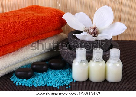 Beautiful spa setting with flower on bamboo mat on bamboo background