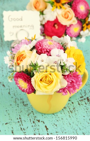 Beautiful bouquet of bright flowers in color vase, on bright background