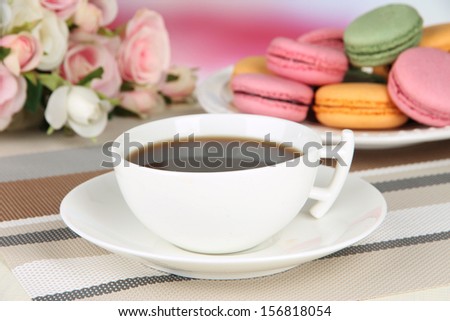 Coffee and macaroons on table on light background
