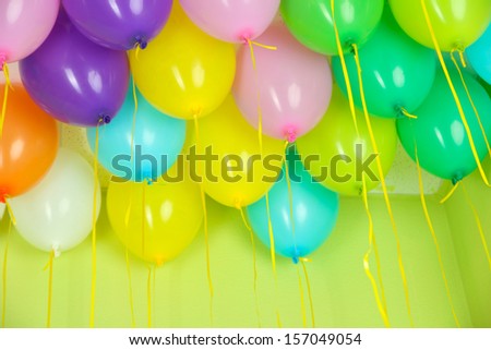 Colorful balloons on green wall background
