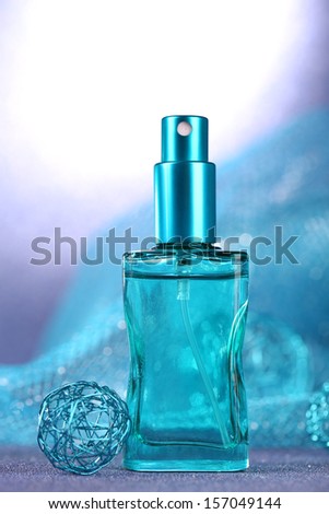 Women perfume in beautiful bottle on blue background