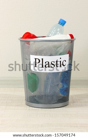 Assorted trash in bucket on room background