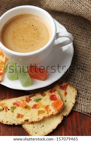 Cup of tasty coffee with Italian biscuit, on wooden background