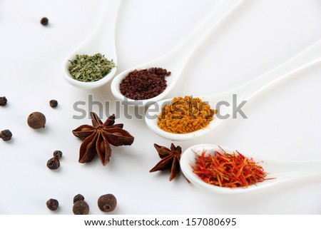 Assortment of spices in  white spoons, isolated on white