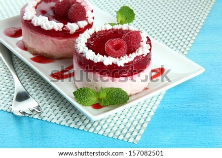 Delicious berry cakes on plate on table close-up