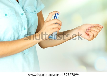 Woman testing perfume on natural background