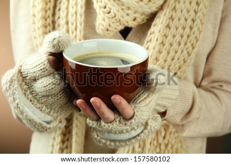 Female hands with hit drink, on color background