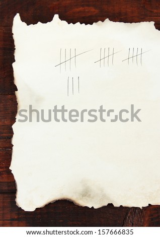 Counting days by drawing sticks on paper on wooden background