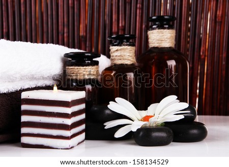 Beautiful spa setting with flower on table on bamboo background