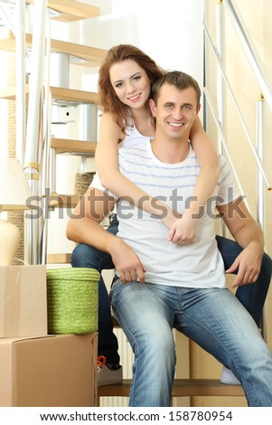 Young couple sitting on stairs in new house