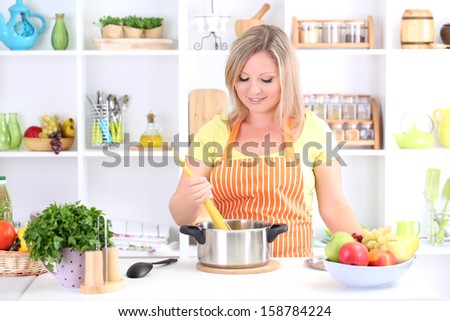 Happy smiling woman in kitchen preparing for healthy meal