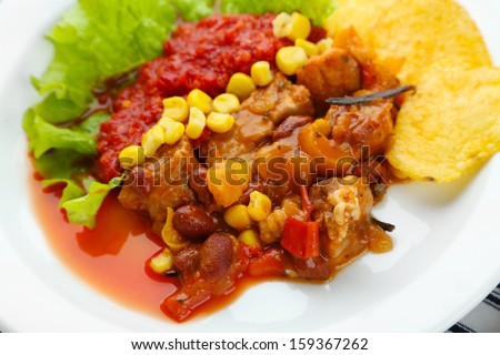 Chili Corn Carne - traditional mexican food, on white plate, on napkin, close up