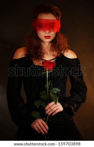Halloween witch with rose on dark background