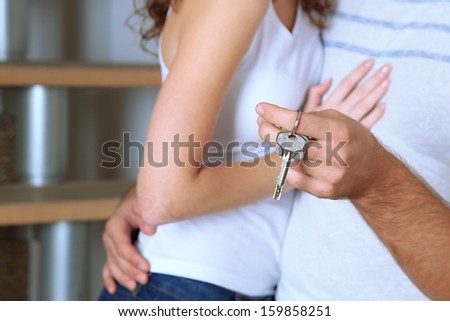 Young couple with keys to your new home close-up