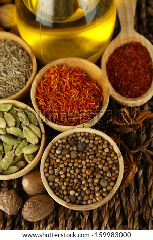 Many different spices and fragrant herbs on braided table close-up