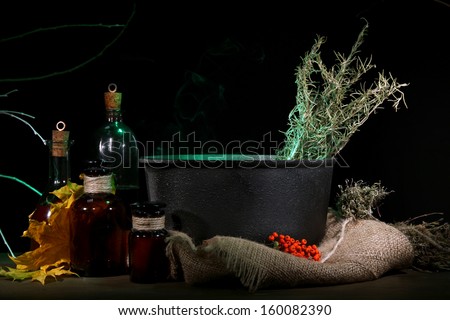 Witch in scary Halloween laboratory on dark color background