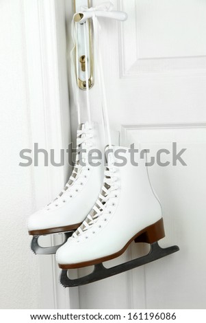 Figure skates hanging on a door knob