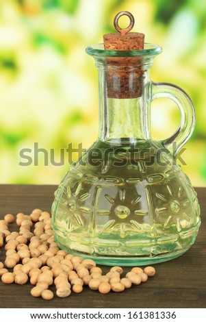 Soy beans and oil on table on bright background