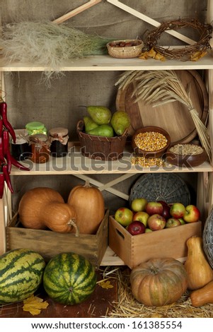 Fruits and vegetables with jars of jam and bowls of grains on shelves close up