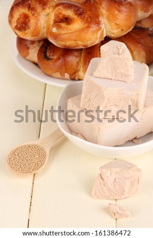 Dry yeast with pastry on wooden table close-up