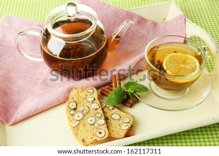 Cup and teapot of green tea with cookies close up