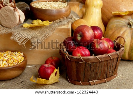 Fruits and vegetables with jar of jam and bowls of grains on sackcloth close up