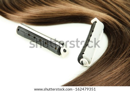 Shiny brown hair with curler isolated on white
