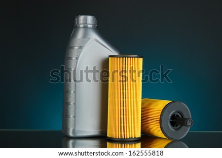 Car oil filters and motor oil can on dark color background