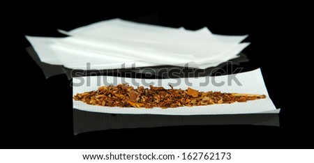 Tobacco and rolling papers, isolated on black